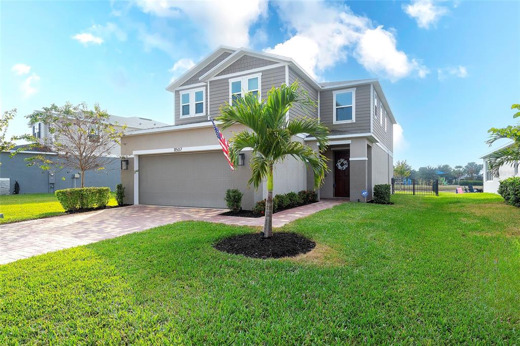 A two-story suburban house with a gray exterior, a two-car garage, and a palm tree — 11507 GALLATIN TRAIL, PARRISH, FL