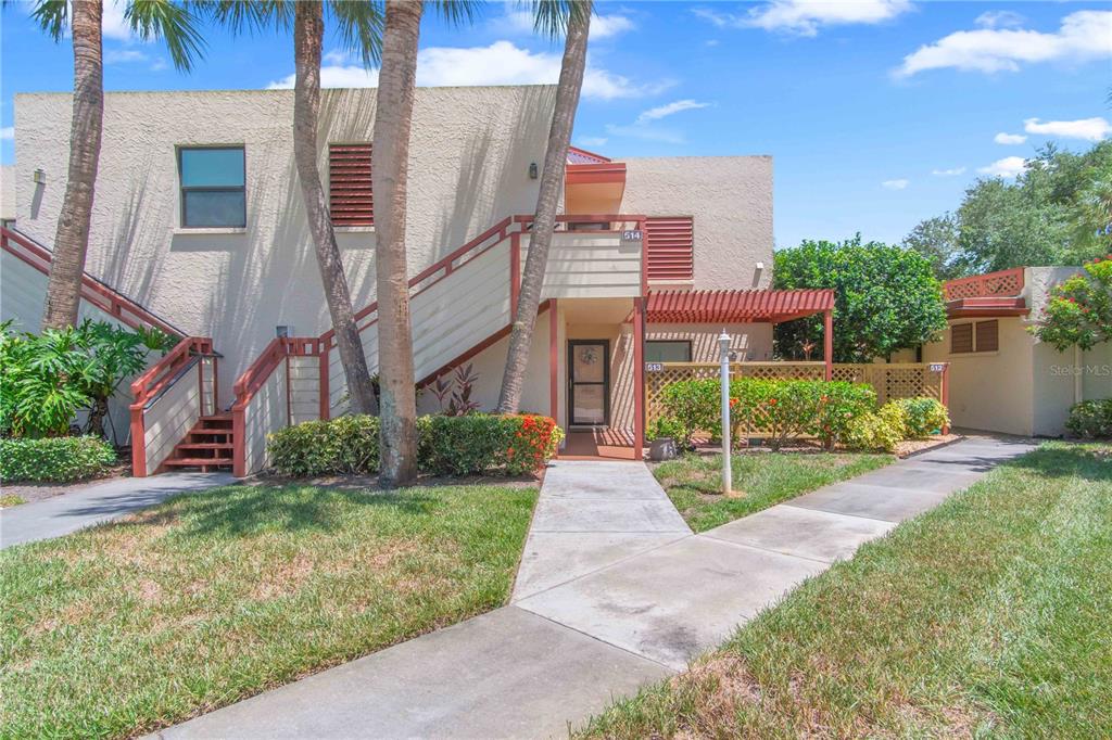 A two-story tan stucco building with exterior stairs and a walkway leading to the entrance — 514 SPRING LAKES BOULEVARD, BRADENTON, FL