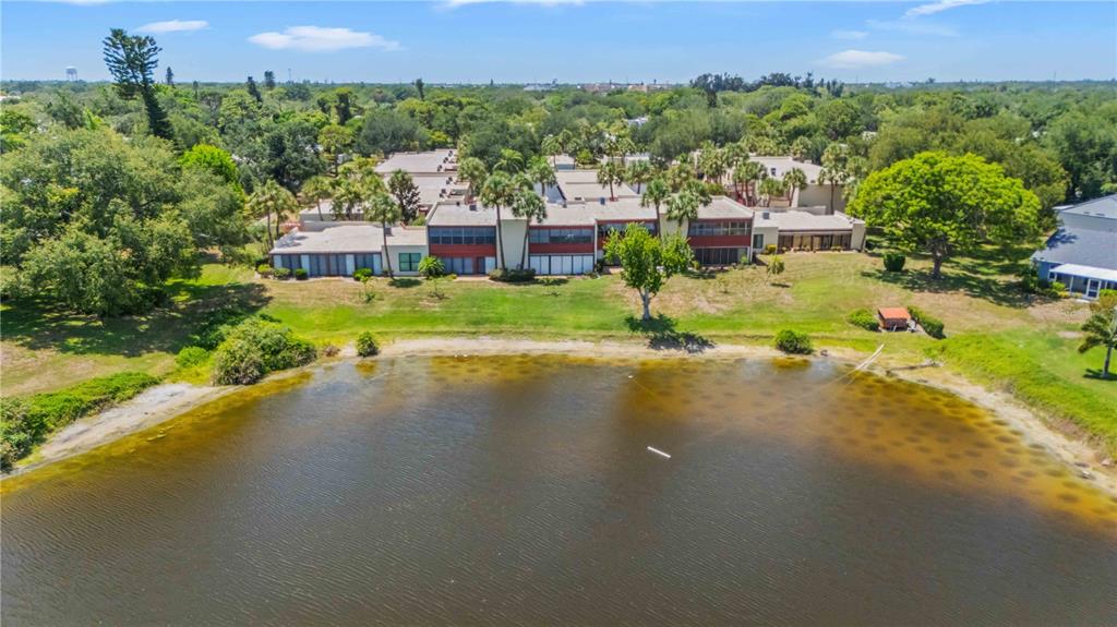 An aerial view of a multi-unit residential building situated along the edge of a lake — 514 SPRING LAKES BOULEVARD, BRADENTON, FL