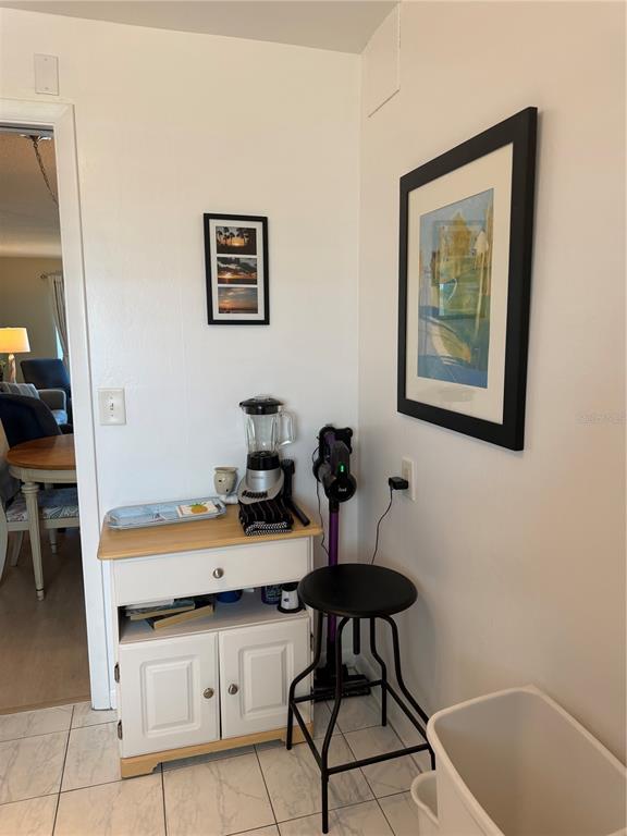 A small white cabinet with a blender sits next to a stool and wall art — 1270 GULF BOULEVARD UNIT 707, CLEARWATER BEACH, FL