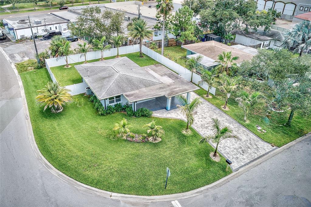 An aerial view of a single-story house with a paved driveway and fenced yard — 2425 BAYWOOD DRIVE E, DUNEDIN, FL
