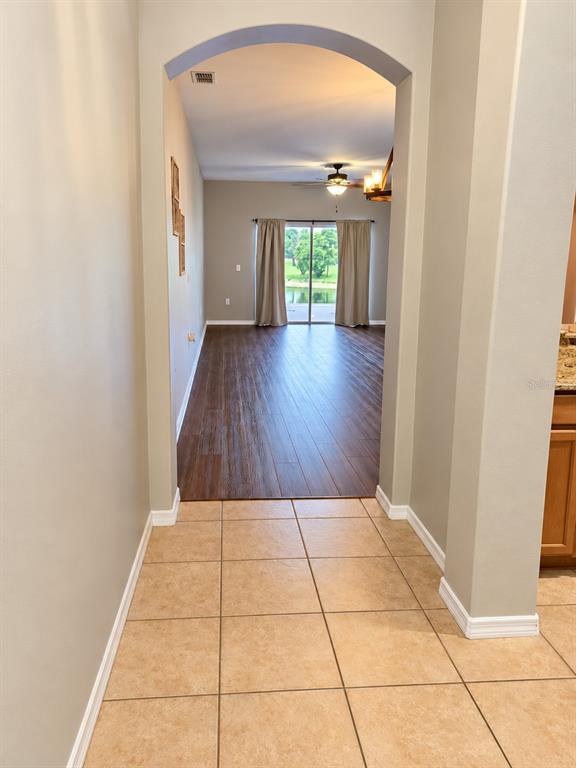 A tiled entryway features a coat rack, a wall sign, and a chandelier — 4086 WINDING VINE, LAKELAND, FL