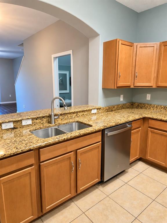 A tiled kitchen area features a window bench, a metal coat rack, and arched entryways — 4086 WINDING VINE, LAKELAND, FL
