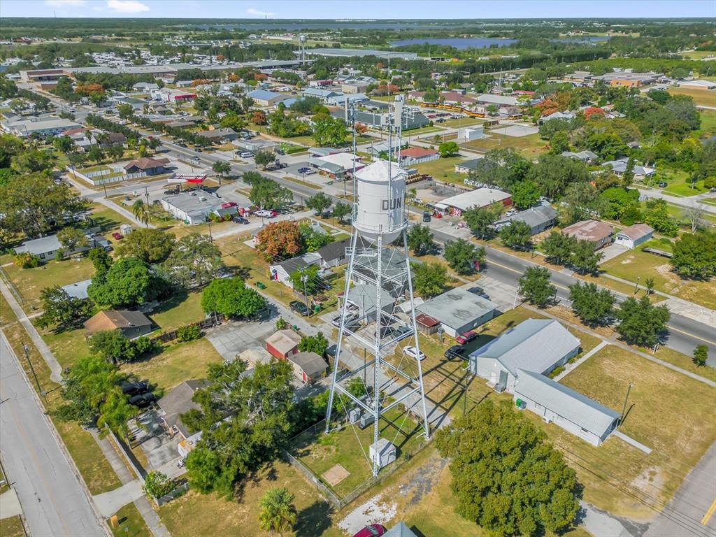 An aerial view shows a tall white water tower standing in a residential neighborhood — 312 E MAIN STREET, DUNDEE, FL