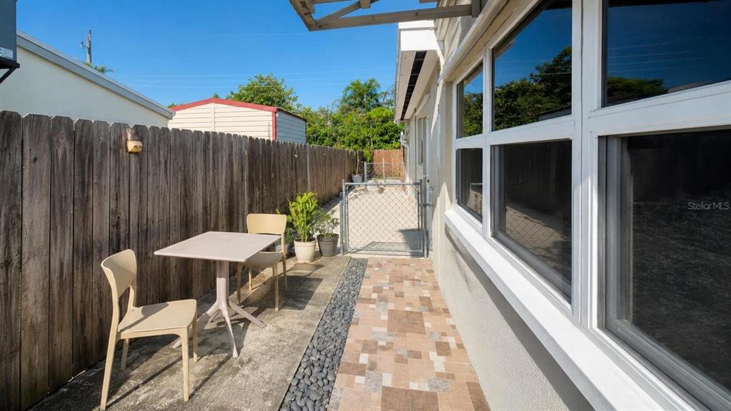 A patio area features a small table, two chairs, a wooden fence, and tiled flooring — 2311 N 58TH AVENUE, HOLLYWOOD, FL