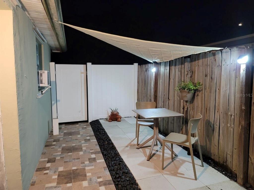 A small outdoor patio features a table, two chairs, a shade sail, and a fence — 2311 N 58TH AVENUE, HOLLYWOOD, FL