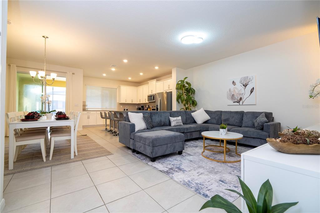 An open-concept living room and dining area with a sectional sofa and kitchen island — 2194 FLEMING MIST PLACE, KISSIMMEE, FL