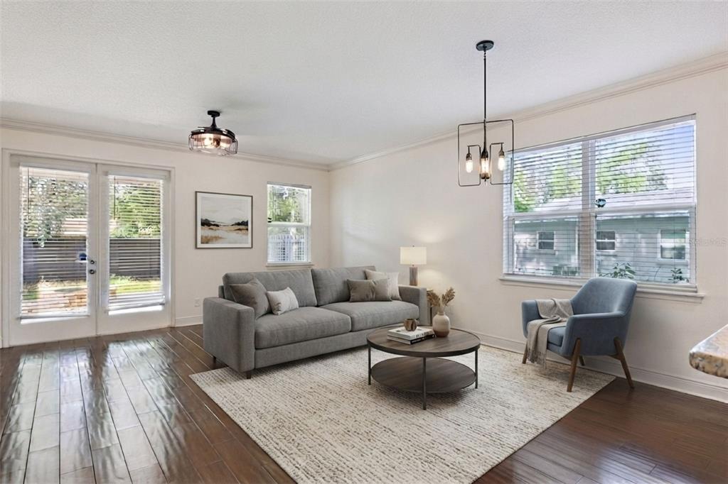 A kitchen with white cabinets and granite countertops overlooks a living area with wood floors — 2806 KILGORE STREET, ORLANDO, FL