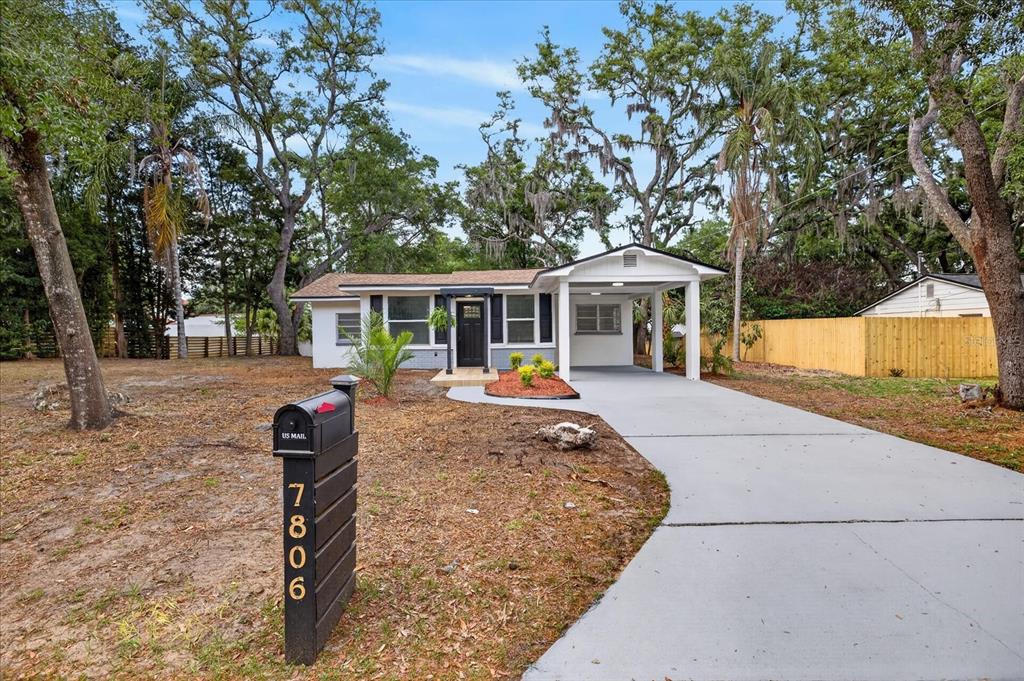 A single-story house with a carport, gray driveway, and a mailbox in the front yard — 7806 E 114TH AVENUE, TAMPA, FL