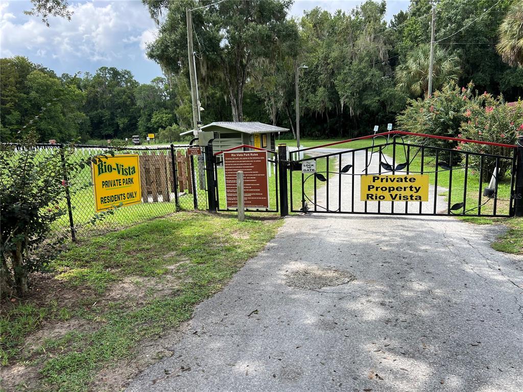 A gated entrance leads to a private park with a small building and wooded area — 18902 SW 108TH LOOP, DUNNELLON, FL