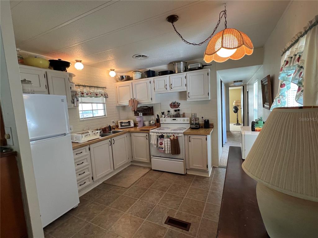 A kitchen with white cabinets, a white refrigerator, a white stove, and tile flooring — 18902 SW 108TH LOOP, DUNNELLON, FL