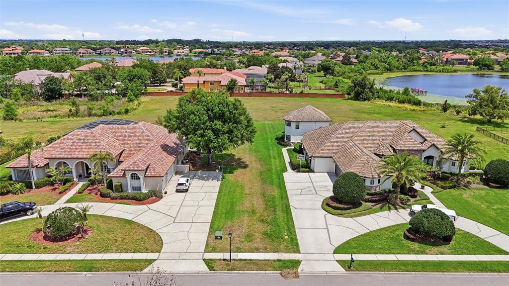 An aerial view shows two suburban houses with tile roofs and driveways separated by grass — 11544 WILLOW GARDENS DRIVE, WINDERMERE, FL