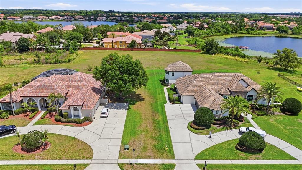 An aerial view shows two large houses with tile roofs and driveways separated by grass — 11544 WILLOW GARDENS DRIVE, WINDERMERE, FL