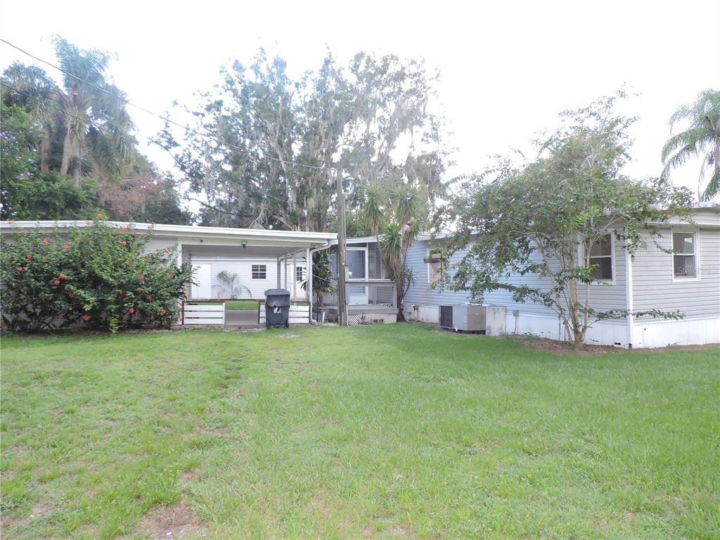 A single-story house with a carport, a screened porch, and a grassy yard — 2530 SNAPPING TURTLE DRIVE, LAKE WALES, FL