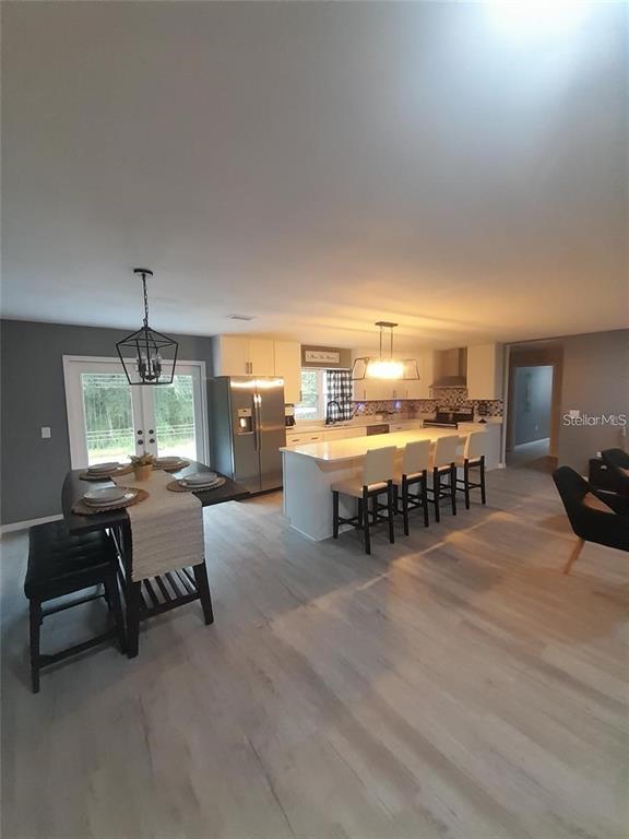 An open-concept kitchen and dining area features white cabinets, a large island, and light flooring — 17873 E HIGHWAY 40, SILVER SPRINGS, FL