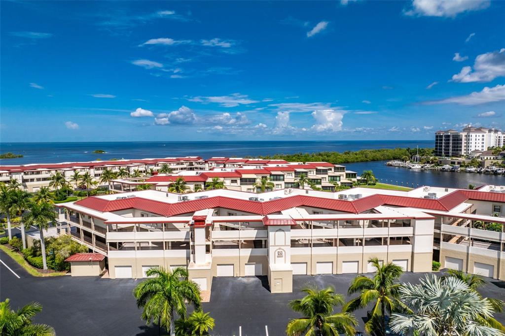 An aerial view of a multi-story residential complex with red roofs near the ocean — 3250 SOUTHSHORE DRIVE UNIT 55B, PUNTA GORDA, FL