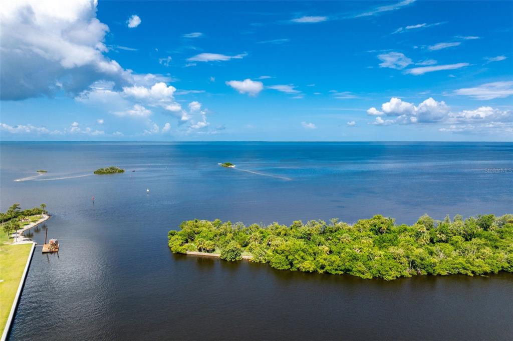 An aerial view shows a lush green island surrounded by a large body of water — 3250 SOUTHSHORE DRIVE UNIT 55B, PUNTA GORDA, FL