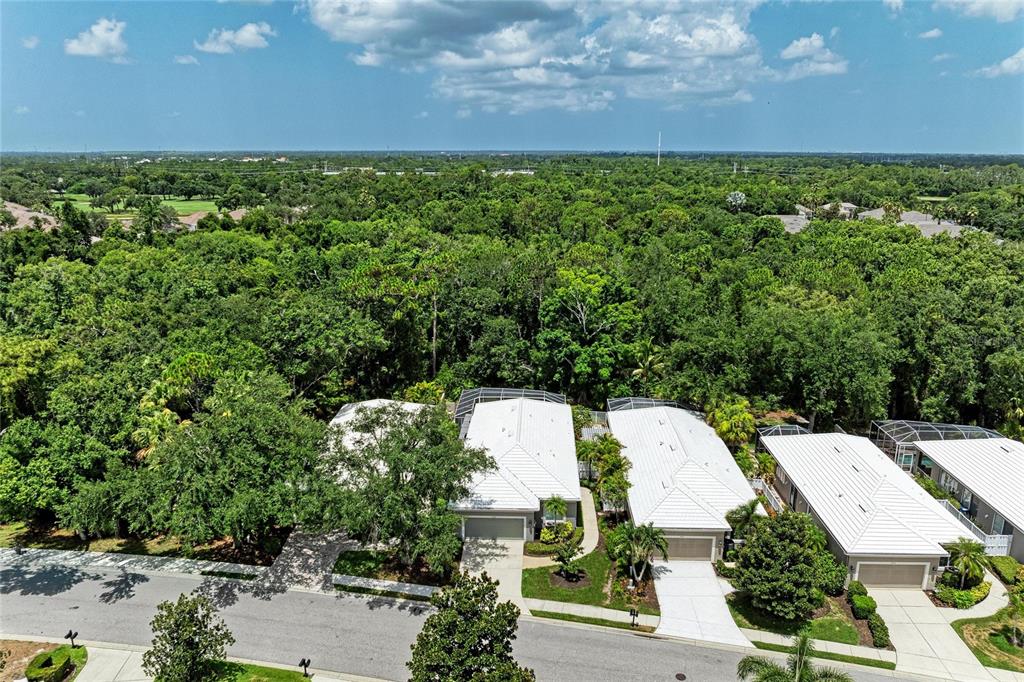 A dining and living area with light wood-look tile floors, a dining table, and pool views — 5002 88TH STREET E, BRADENTON, FL