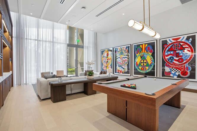 A modern lounge area features a pool table, a long sofa, and large colorful wall art — 3015 S YSABELLA AVENUE UNIT 2703, TAMPA, FL