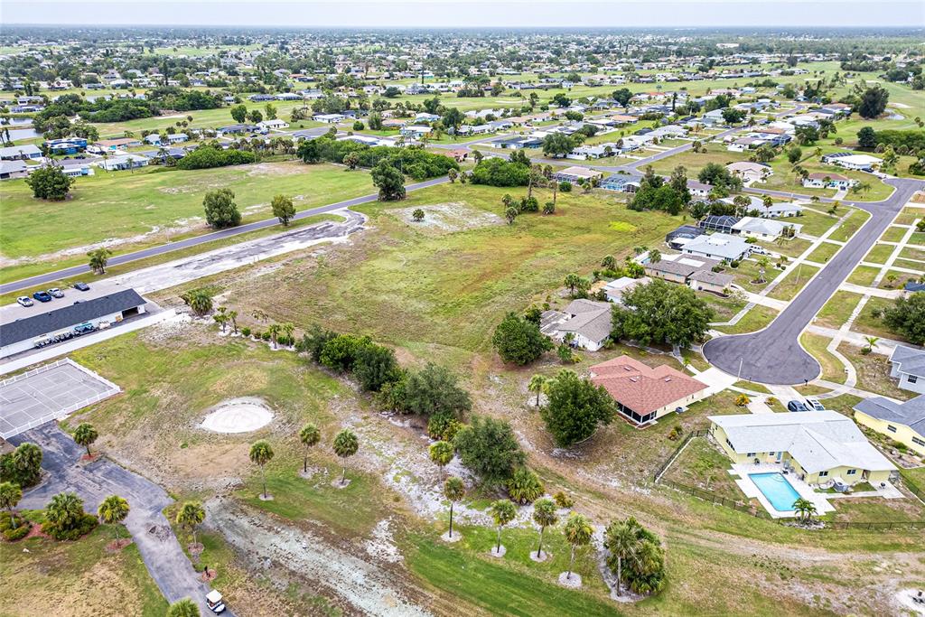An aerial view shows a vacant lot surrounded by residential homes, roads, and landscaping — 3 GOLFVIEW ROAD, ROTONDA WEST, FL