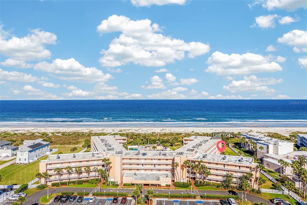 An aerial view shows a multi-story beachfront condominium complex with a parking lot — 4 OCEAN TRACE ROAD UNIT 104, ST AUGUSTINE, FL