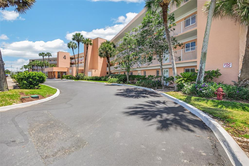 A multi-story peach-colored apartment building with palm trees and a paved driveway — 4 OCEAN TRACE ROAD UNIT 104, ST AUGUSTINE, FL