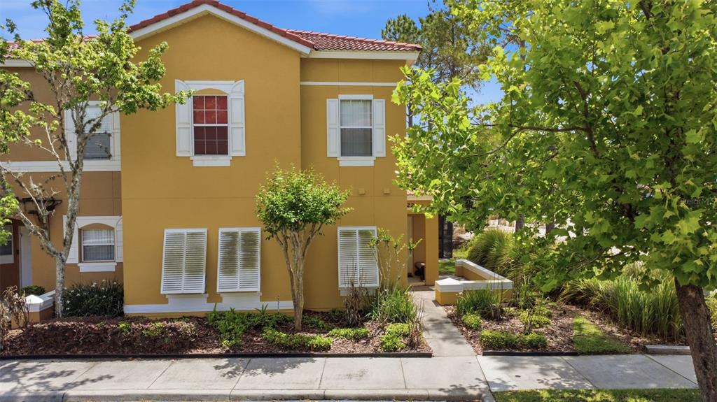A covered entryway with a white door, a small bench, and a view of palm trees — 4722 ORMOND BEACH WAY, KISSIMMEE, FL