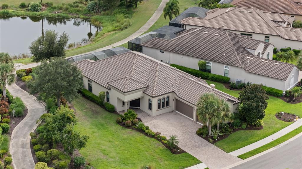 An aerial view shows a single-story house with a tiled roof, driveway, and backyard pool — 5311 BENITO COURT, BRADENTON, FL