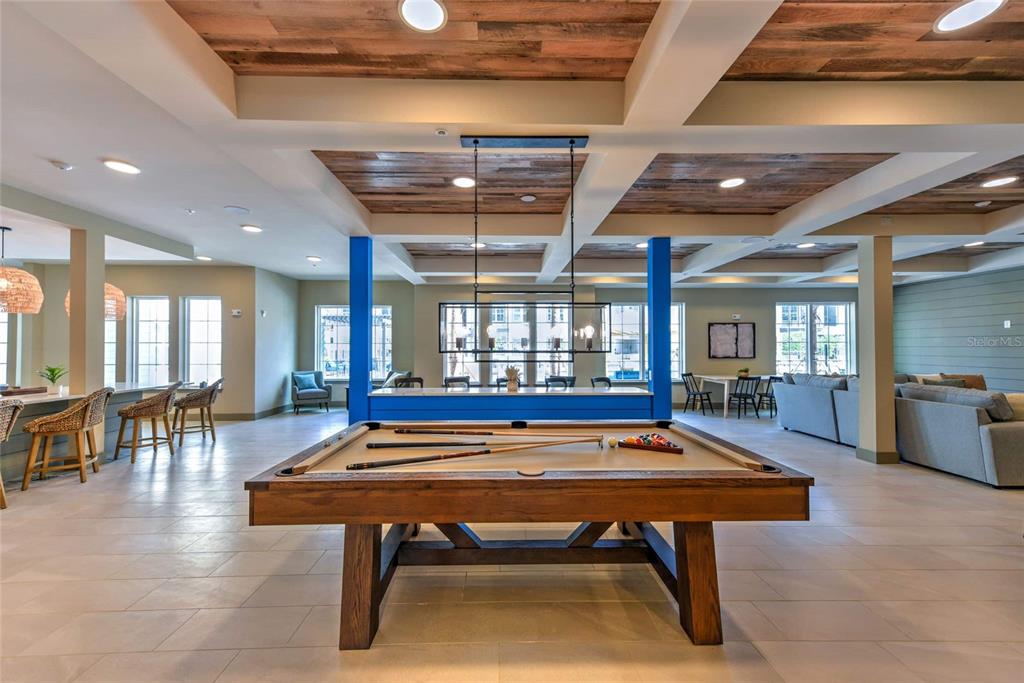 A spacious recreation room features a pool table, wood-paneled ceiling, and blue support columns — 6629 DAN DICIOLLA DRIVE UNIT A4, WILDWOOD, FL