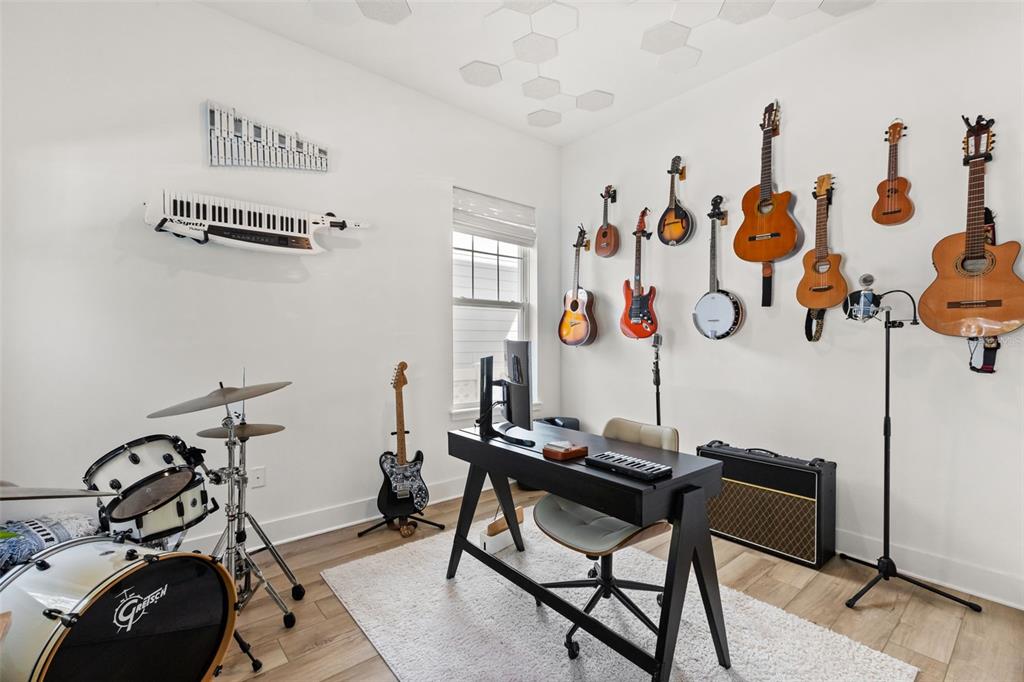 A home music studio features a drum set, a desk, and multiple instruments mounted on the wall — 150 HAMMOCK PRESERVE LOOP, OAKLAND, FL