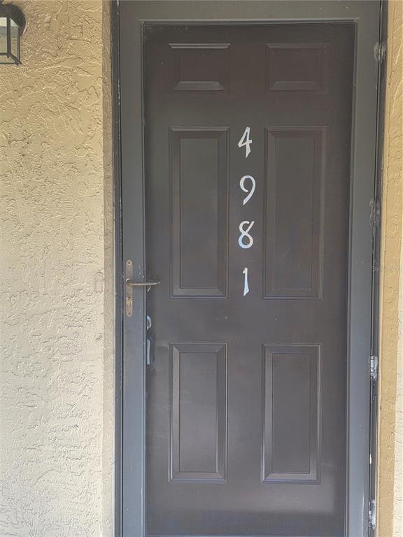 A dark brown front door with the house number 4981 displayed vertically on the panel — 4981 PURITAN CIRCLE UNIT 504, TAMPA, FL