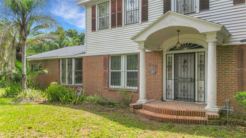 A two-story brick and siding house sits behind a circular driveway and large oak trees — 820 S OAK AVENUE, BARTOW, FL