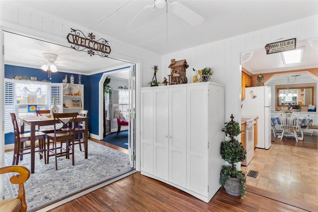 A white cabinet stands between a dining room with blue walls and a kitchen — 2470 KAREN DRIVE, MOUNT DORA, FL