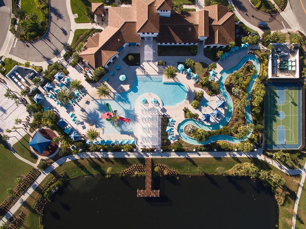 An aerial view shows a community clubhouse with a swimming pool, lazy river, and basketball court — 2431 DUBAI STREET, KISSIMMEE, FL
