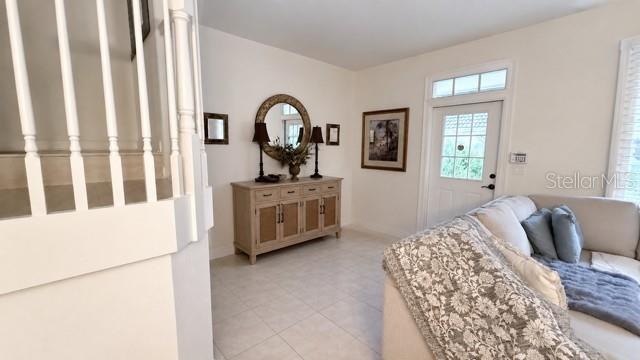 A living room features a light-colored sofa, a wooden console table, and a staircase — 8074 MURANO CIRCLE, PALM BEACH GARDENS, FL