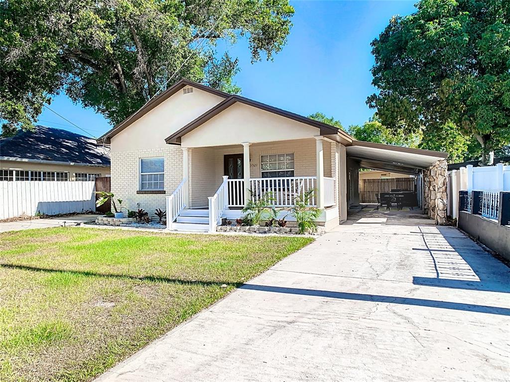 A single-story house with a brick facade, front porch, and an attached carport — 3321 W AILEEN STREET, TAMPA, FL