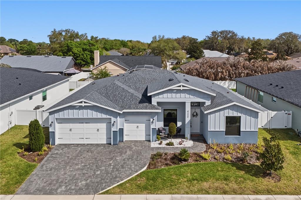An aerial view of a single-story house with a gray roof and a paved driveway — 9223 EAGLES PERCH PLACE, ORLANDO, FL