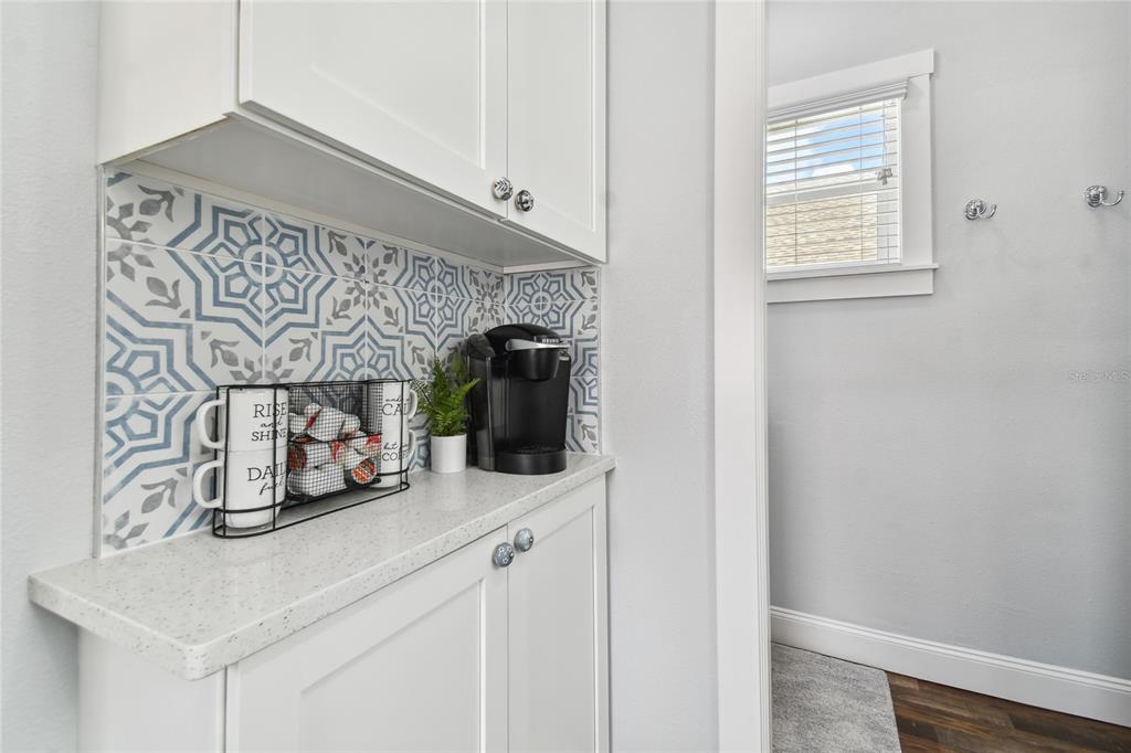 A coffee station features white cabinets, a patterned tile backsplash, and a quartz countertop — 602 1/2 SKINNER BOULEVARD, DUNEDIN, FL
