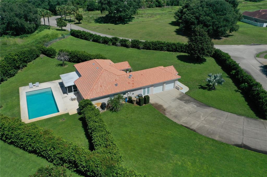 An aerial view shows a house with a pool and a large yard outlined in white — 12623 LAKE DENISE BOULEVARD, CLERMONT, FL