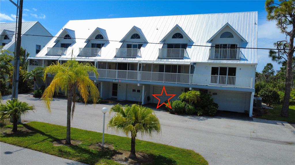 An exterior view of a multi-story townhouse complex with a red star marking a garage — 6800 PLACIDA ROAD UNIT TH-3D, ENGLEWOOD, FL