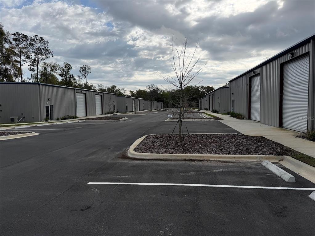 An outdoor view of a commercial warehouse complex with multiple metal buildings and parking spaces — 5741 S PINE AVENUE, OCALA, FL