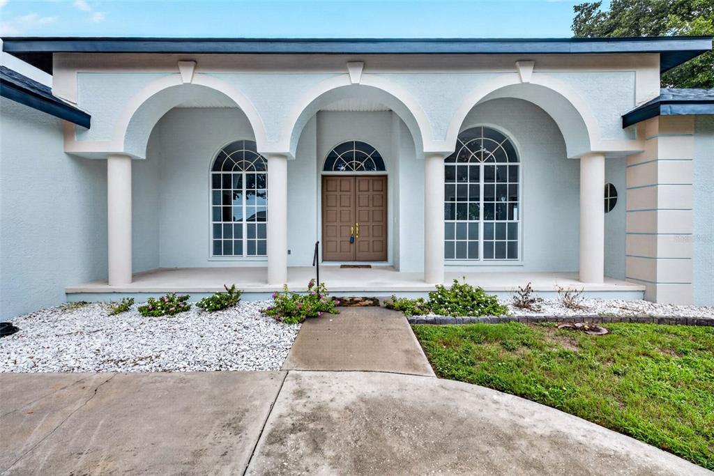 An aerial view shows a teal, single-story house with a dark roof and a circular driveway — 8911 RIVERLACHEN WAY, RIVERVIEW, FL