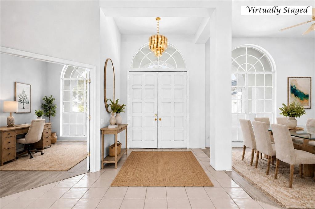 A bright entryway features white double doors, a gold chandelier, and tile flooring — 8911 RIVERLACHEN WAY, RIVERVIEW, FL