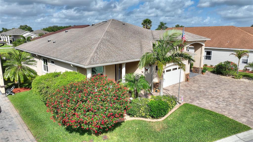An exterior view of a single-story house with a paved driveway and landscaped front yard — 416 MOTORCOACH DRIVE S, POLK CITY, FL