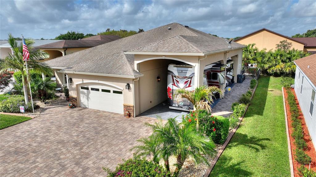 An aerial view of a house with a large attached RV garage and paved driveway — 416 MOTORCOACH DRIVE S, POLK CITY, FL