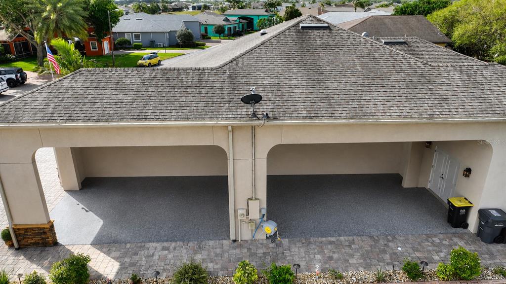 An aerial view of a two-car open-air carport with a paved floor and shingled roof — 416 MOTORCOACH DRIVE S, POLK CITY, FL