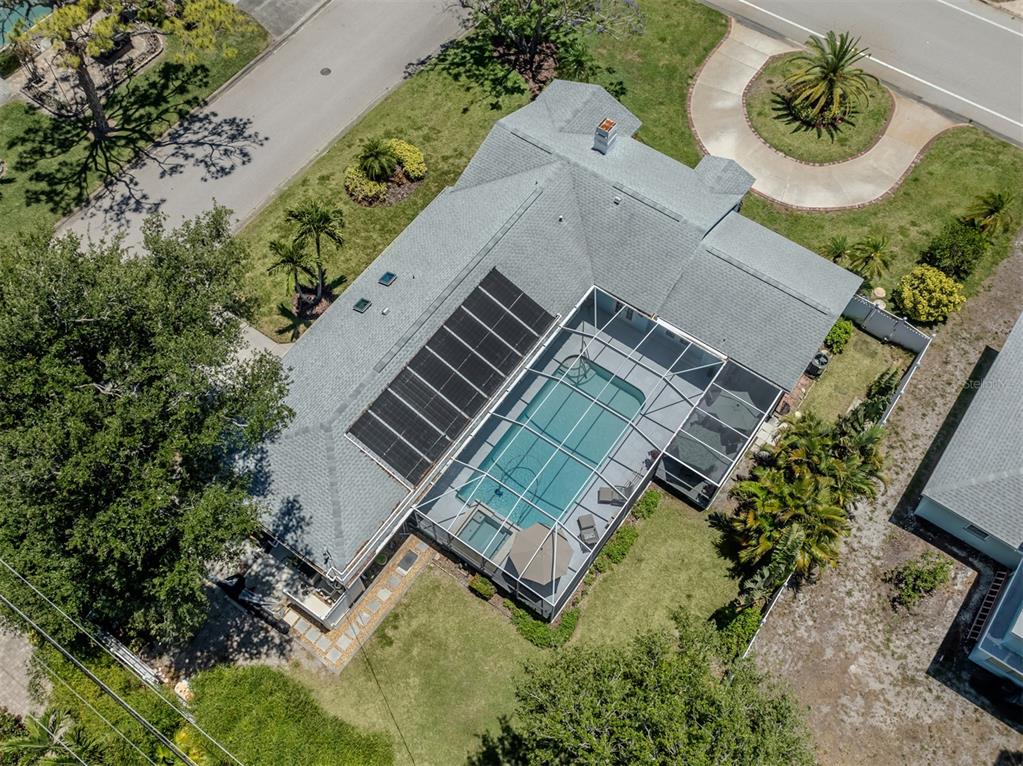 An aerial view shows a coastal neighborhood with houses, swimming pools, and the ocean beyond — 500 ALHAMBRA ROAD, VENICE, FL
