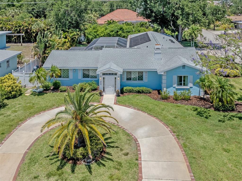 A light blue house features a white front door, a brick-bordered walkway, and a chimney — 500 ALHAMBRA ROAD, VENICE, FL