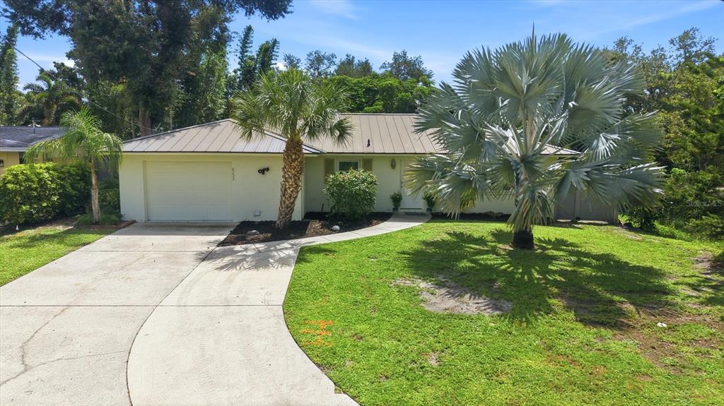 A living room features light tile flooring, a brown sofa, and two beige armchairs — 6233 ROCKEFELLER AVENUE, SARASOTA, FL