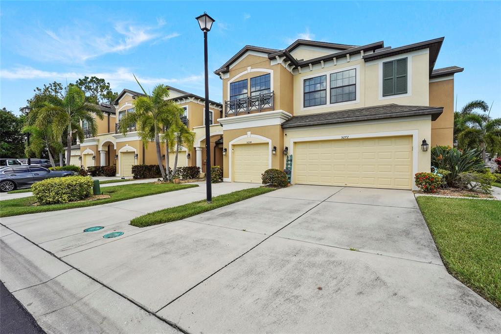 An open-concept living and kitchen area featuring wood-paneled walls, tile flooring, and a staircase — 5274 78TH ST CIRCLE E, BRADENTON, FL